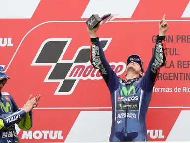Pembalap Movistar Yamaha Maverick Vinales merayakan kemenangan di atas podium usai menjuarai MotoGP Argentina di Sirkuit Termas de Rio Hondo, Minggu (9/4).Vinales menyelesaikan balapan dengan catatan waktu 41 menit 45,060 detik (AP Photo/Nicolas Aguilera)