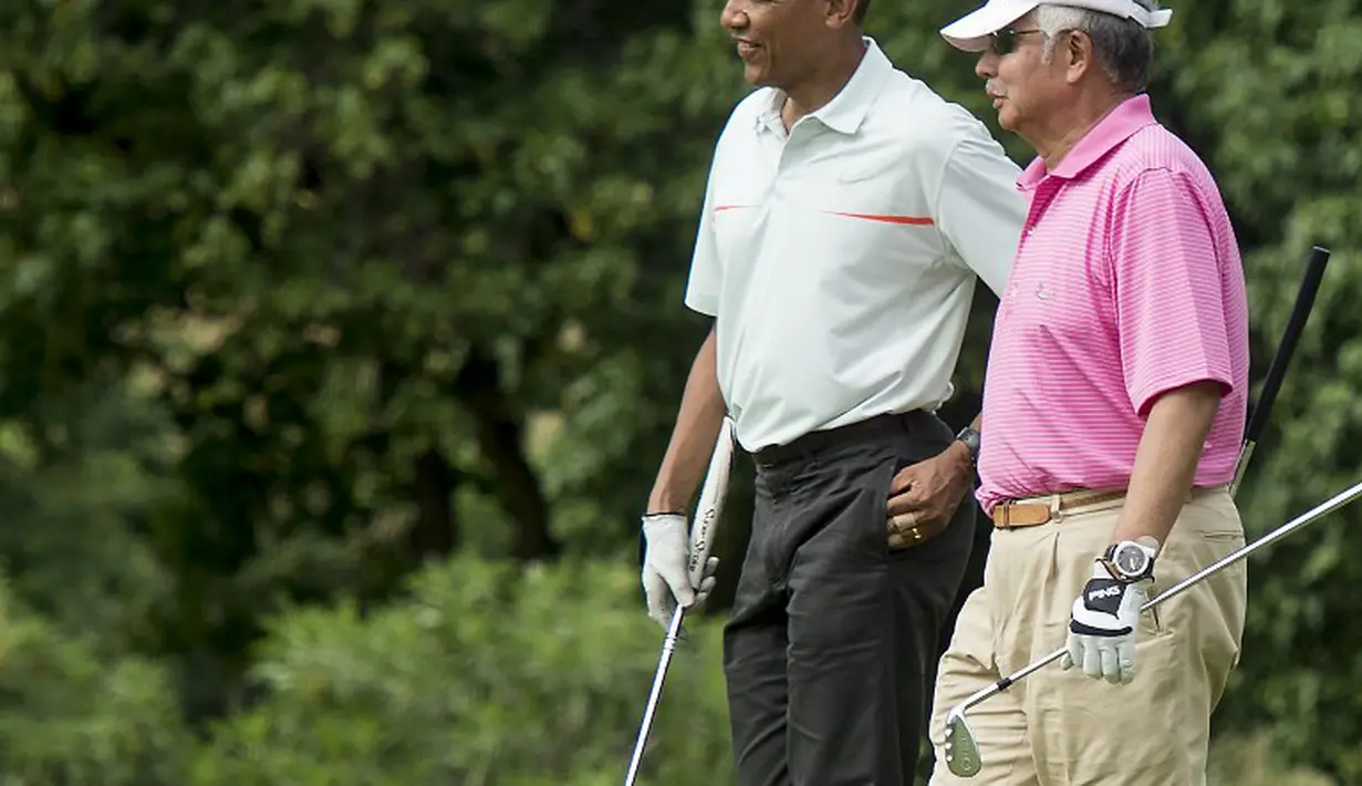Barack Obama bermain golf bersama Perdana Menteri Malaysia, Najib Razak (kanan) di pangkalan militer Marine Corps, Hawaii, Rabu (24/12/2014). (AFP PHOTO/Nicholas KAMM)