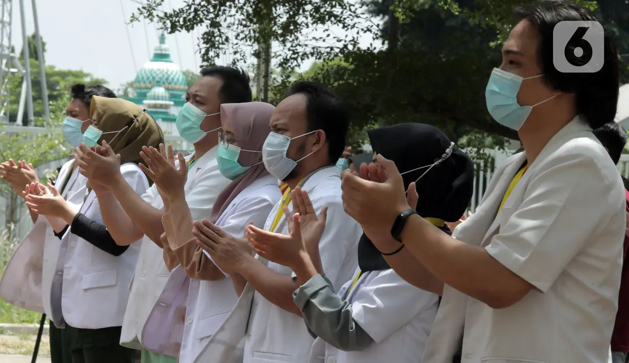 Tenaga kesehatan bertepuk tangan selama 56 detik pada peringatan Hari Kesehatan Nasional ke-56 di RSD Wisma Atlet, Jakarta, Kamis (12/11/2020). Aksi tersebut sebagai bentuk penghargaan kepada tenaga kesehatan yang berjuang menghadapi pandemi COVID-19. (Liputan6.com/Herman Zakharia)
