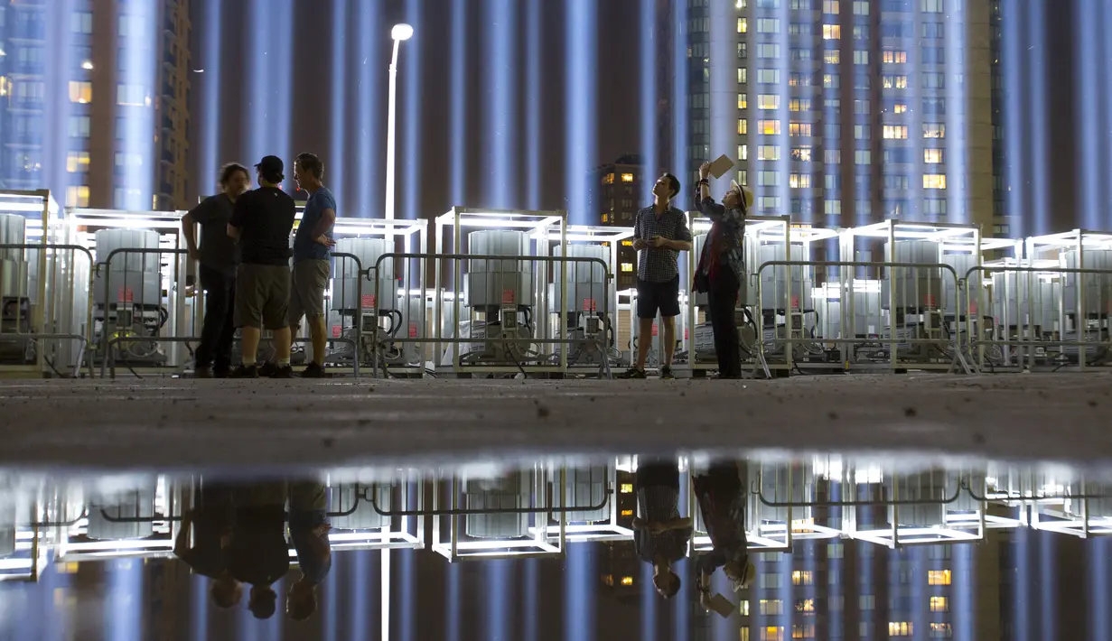 Pengunjung menikmati keindahan lampu sorot di World Trade Center (WTC) dipancarkan ke langit kota New York, AS, (9/9/2015). Acara dinamakan Tribute in Light memperingati 14 tahun tragedi terorisme 11 September di Amerika Serikat. (REUTERS/Andrew Kelly)