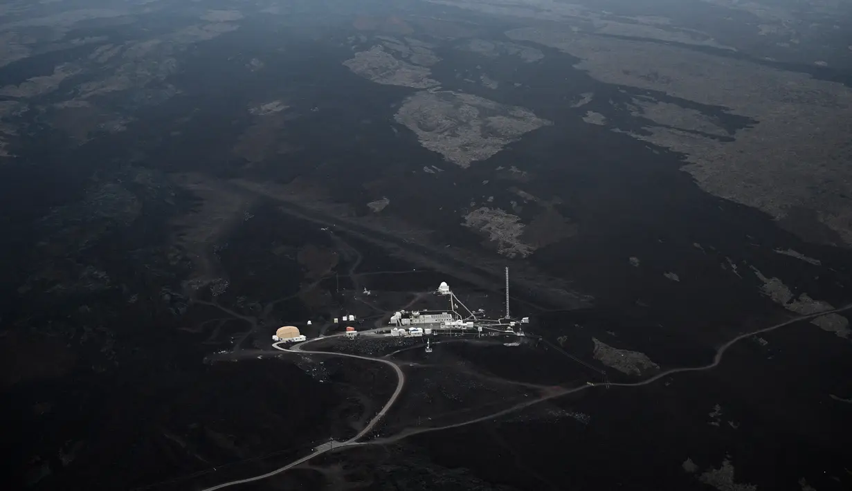 Observatorium Mauna Loa terlihat dari udara di atas Gunung Api Mauna Loa dekat Kailua-Kona, Hawaii, Senin (12/12/2022). Dengan statusnya yang kini berubah menjadi waspada, letusan Mauna Loa masih berlangsung, tetapi menimbulkan bahaya terbatas. (Robyn BECK / AFP)