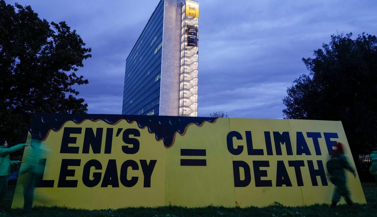 Aktivis organisasi lingkungan Greenpeace membuka spanduk di samping gedung kantor pusat ENI—perusahaan minyak dan gas Italia—di Roma, Selasa, 5 Desember 2023. (AP Photo/Andrew Medichini)