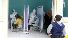 Seorang anak menyaksikan paramedis melakukan swab test PCR kepada warga di Puskesmas Kramat Jati, Jakarta Timur, Rabu (13/1/2020). Setiap harinya, Puskesmas Kramat Jati menyediakan kuota 300 swab test PCR  secara gratis untuk memutus mata rantai penyebaran COVID-19. (merdeka.com/Arie Basuki)