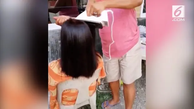 Seorang emak-emak kini tengah menjadi perbincangan hangat. Ia meluruskan rambut kerabatnya menggunakan setrika baju.