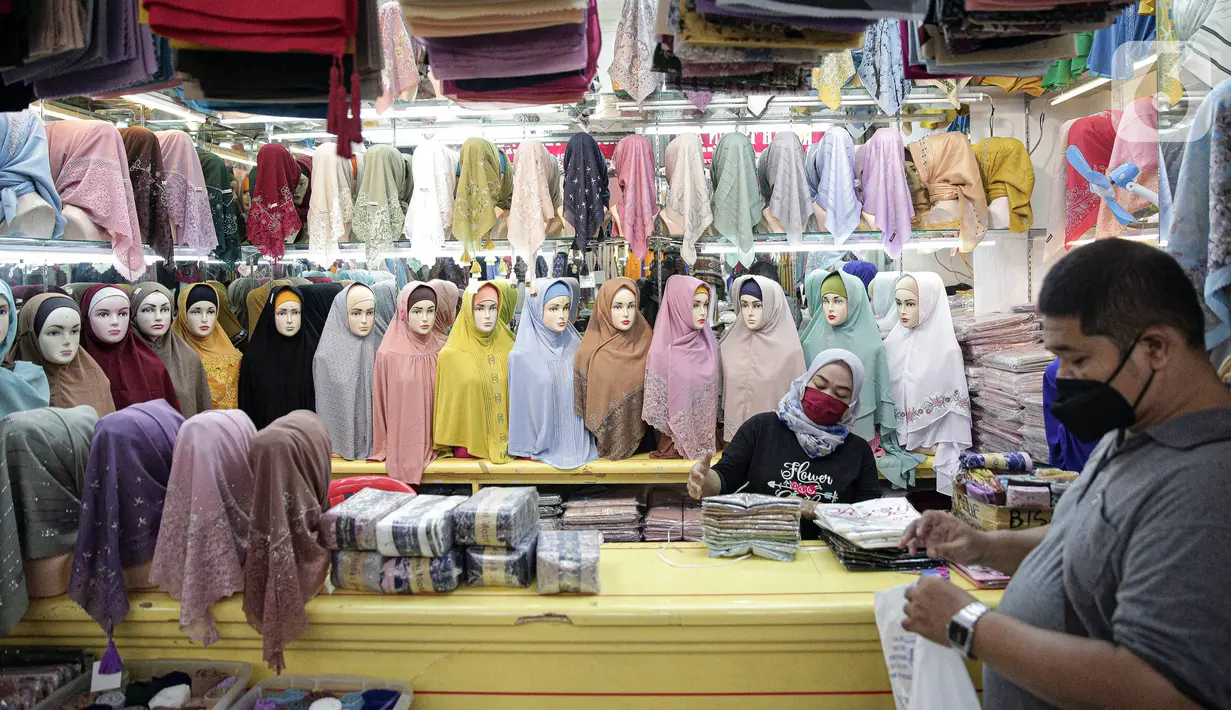 Pedagang menunggu pembeli perlengkapan ibadah di Pasar Tanah Abang Blok A, Jakarta, Senin (4/4/2022). Penjualan busana muslim seperti mukena, kerudung, sajadah dan sarung mengalami peningkatan di bulan Ramadhan. (Liputan6.com/Faizal Fanani)