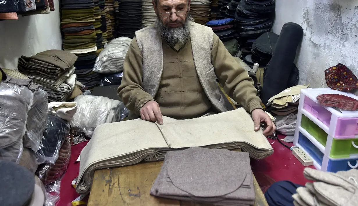 Seorang pengrajin membuat topi tradisional di sebuah bengkel kerja di Peshawar, Pakistan barat laut, pada 28 Desember 2020. Topi tradisional yang terbuat dari bahan wol ini sangat populer di kalangan warga Pakistan selama musim dingin. (Xinhua/Saeed Ahmad)