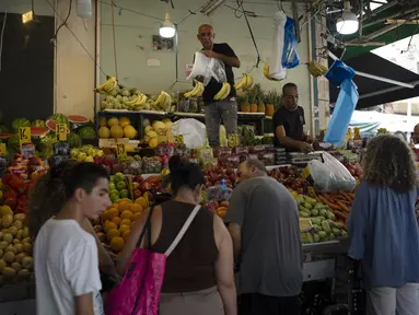 Orang-orang membeli buah dari pasar jalanan di Haifa, Israel, Jumat, 16 Agustus 2024.  (AP Photo/Leo Correa)