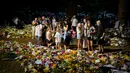 Orang-orang berkumpul di depan karangan bunga untuk Ratu Elizabeth II di Green Park, dekat Istana Buckingham di London, Senin (12/9/2022). Elizabeth juga sempat bertugas selama Perang Dunia II sebagai mekanik selagi menjabat sebagai kepala negara. (AP Photo/Markus Schreiber)