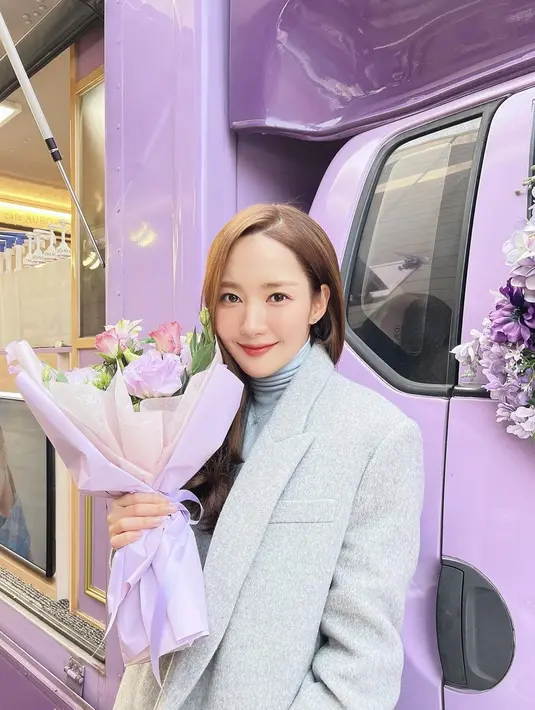 Park Min-young saat memakai jas ini kian menujukkan sisi femininnya. Sambil memegang buket dan tersenyum, Park Min-young sukses bikin penggemarnya kian menyukainya. Penampilan menawan Park Min-young ini disebut netizen layaknya bidadari. (Liputan6.com/IG/@rachel_mypark)