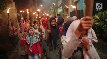 Anak-anak mengikuti pawai obor menyambut Tahun Baru Islam 1 Muharam 1439 Hijriah kawasan Cikini, Jakarta, Rabu (20/9). Tanggal 21 September menjadi awal tahun bagi penanggalan kalender 1439 Hijriah. (Liputan6.com/Faizal Fanani)