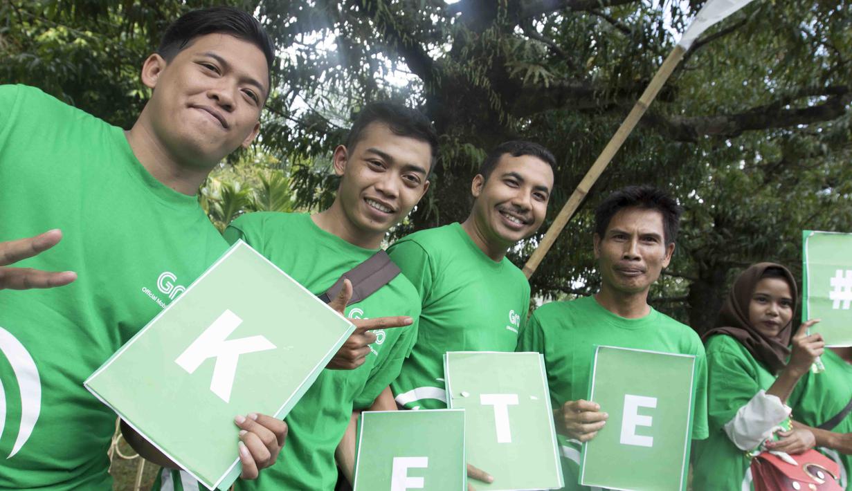 Sejumlah mitra Grab memberikan dukungan saat obor Asian Games melintas di Banjarmasin, Kalimantan Selatan, Senin (30/7/2018). Sebanyak 53 kota di Indonesia akan dilalui oleh obor Asian Games. (Bola.com/Reza Bachtiar)