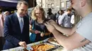 Gubernur Bank Inggris, Carney mengetes uang keluaran baru saat ia membeli makan siang di Whitecross Street Market di London, Selasa (13/9). Uang tersebut terbuat dari plastik film berbahan polimer. (REUTERS / Stefan Wermuth)