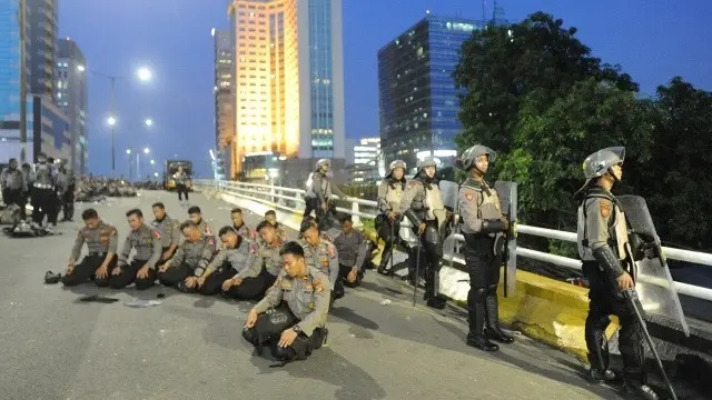 Tengah Bertugas Mengamankan, Polisi Tetap Sempatkan Salat Maghrib