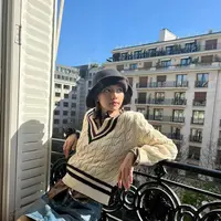 Momen Lisa di Paris, berpose di pinggir jendela kamar hotelnya dengan outfit bernuansa preppy. Kemeja cokelat ditumpuknya dengan sweater dan dipadu dengan mini skirt jeans. Di sini, ia mengenakan bucket hat hitam. Foto: Instagram.