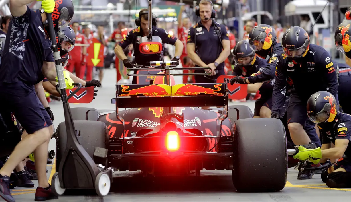 Tim mekanik Red Bull saat mempersiapkan mobil Max Verstappen pada sesi latihan bebas F1 GP Singapura di Marina Bay City Circuit, (15/9/2017). (AP/Wong Maye-E)