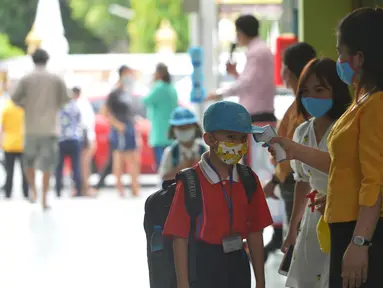 Seorang siswa diukur suhu tubuhnya di pintu masuk sebuah sekolah di Bangkok, Thailand (1/7/2020). Sekolah-sekolah di Thailand telah dibuka kembali pada Rabu (1/7). (Xinhua/Rachen Sageamsak)
