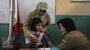 Seorang anak mengikuti kegiatan Bulan Imunisasi Anak sekolah (BIAS) di SDN 11 Pagi, Lubang Buaya, Jakarta, Selasa (4/10). Kegiatan ini untuk mewujudkan Indonesia bebas dari kanker serviks. (Liputan6.com/Faizal Fanani)
