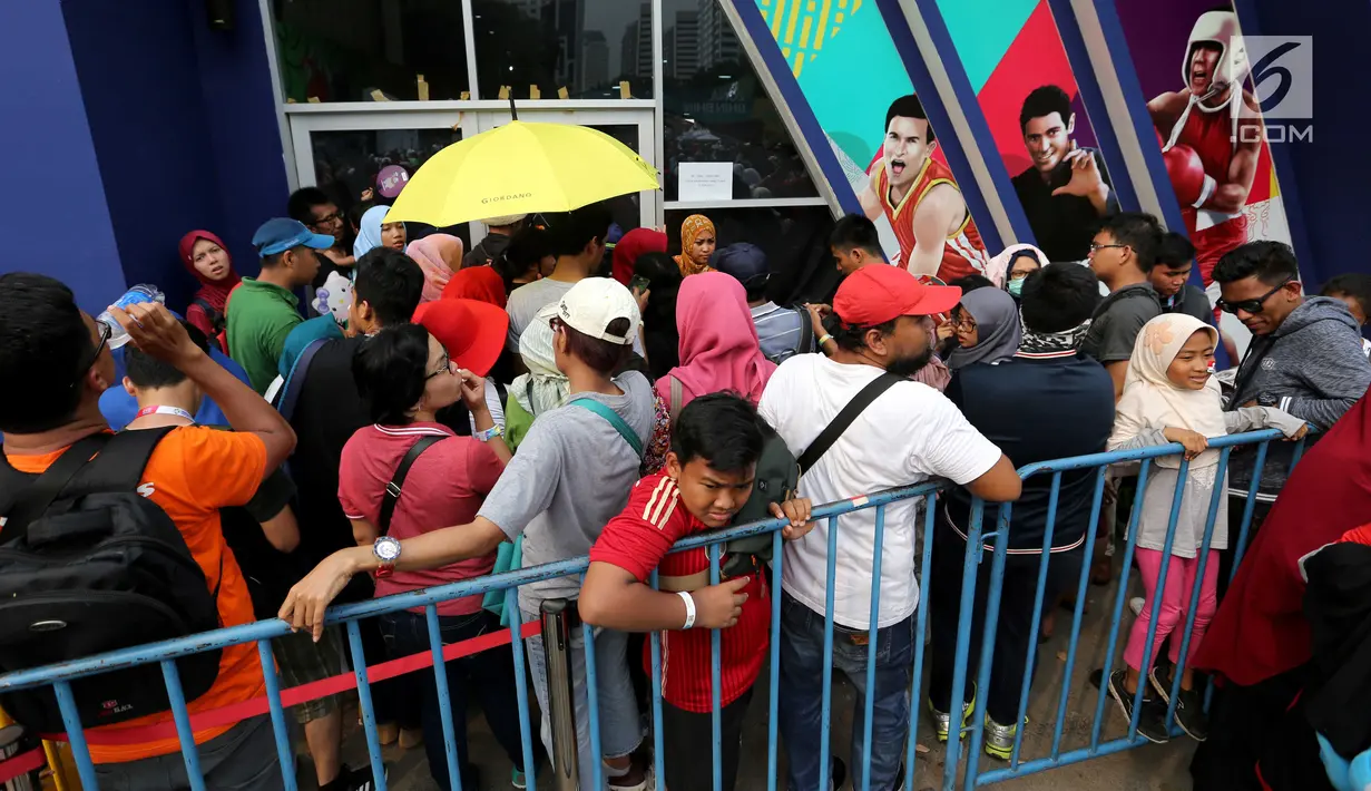 Pengunjung antre di depan pintu Merchandise Superstore jelang Closing Ceremony Asian Games 2018 di kawasan Gelora Bung Karno, Jakarta, Minggu (2/9). Mereka rela antre berjam-jam sebelum toko dibuka. (Liputan6.com/Fery Pradolo)
