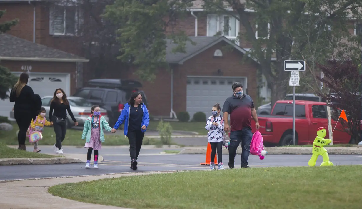 Para murid dan orang tuanya tiba di sebuah sekolah di Mississauga, Ontario, Kanada (9/9/2020). Beberapa sekolah di Ontario dibuka kembali pada Rabu (9/9), menawarkan kombinasi kelas tatap muka dan pembelajaran daring (online) bagi para murid. (Xinhua/Zou Zheng)