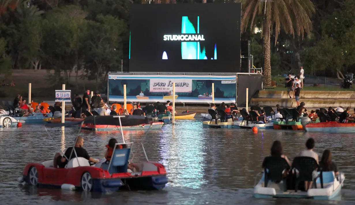 Orang-orang duduk di atas perahu saat "berlayar" di bioskop terapung, Tel Aviv, Israel, 20 Agustus 2020. Bioskop terapung ini merupakan inisiatif pemerintah Kota Tel Aviv untuk menyediakan acara budaya bagi warga selama pembatasan di tengah pandemi COVID-19. (Xinhua/JINI/Gideon Markowicz)