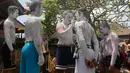 Para pemuda melukis diri mereka untuk persiapan ritual Hindu yang disebut "Grebeg" di Desa Tegallalang, Bali, Rabu (30/1). Tradisi ritual berkeliling kampung dengan riasan tubuh warna-warni itu dipercaya sebagai penangkal Roh jahat. (AP/Firdia Lisnawati)