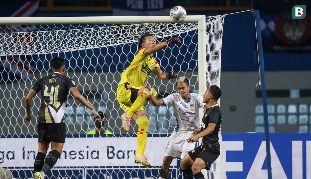 Kiper Dewa United, Rivky Mokodompit berusaha menghalau bola dari ancaman pemain PSIM Yogyakarta, Hapidin (kedua dari kanan) dalam matchday pertama Grup Y Babak 8 besar Liga 2 2021 di Stadion Wibawa Mukti, Cikarang, Kamis (16/12/2021). (Bola.com/Bagaskara Lazuardi)