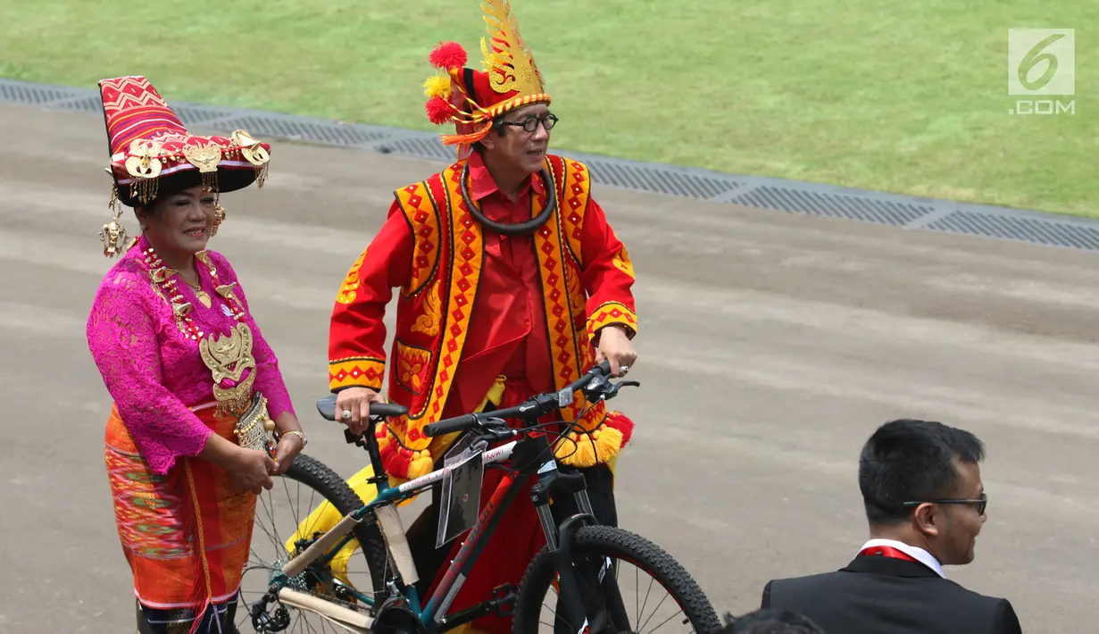 Menkumham, Yasonna H Laoly membawa hadiah sepeda dari Presiden Jokowi usai peringatan HUT RI ke 72 di Istana Merdeka, Jakarta, Kamis (17/8). Yasonna mengenakan pakaian adat Nias saat perayaan Hari Kemerdekaan Indonesia. (Liputan6.com/Pool)