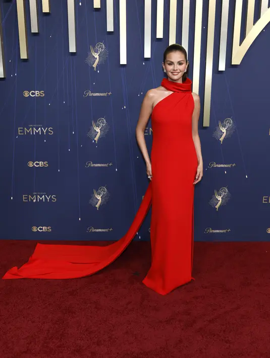 Tunangan Benny Blanco itu tampil menyala dengan gaun halter neck asimetris berwarna merah. Gaun ini memiliki aksen kerah terbungkus dan ekor yang mengalir. [Louis Vuitton]