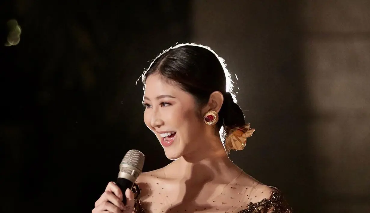 Kembali jadi host, Putu Ayu Anggun dengan gaun malam. Gaun v-neck berwarna cokelat itu memiliki detail embroidery yang nampak kontras dengan warna kulit Putu Ayu [instagram/ayusarasw]