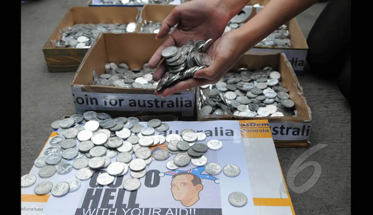 Puluhan Garda Pemuda Nasdem menunjukan ribuan koin untuk PM Tony Abbot di depan kantor Kedutaan Besar Australia, Jakarta, Jumat (27/2/2015). Dalam aksinya mereka menyerahkan koin tersebut ke Kedubes Australia. (Liputan6.com/Herman Zakharia)