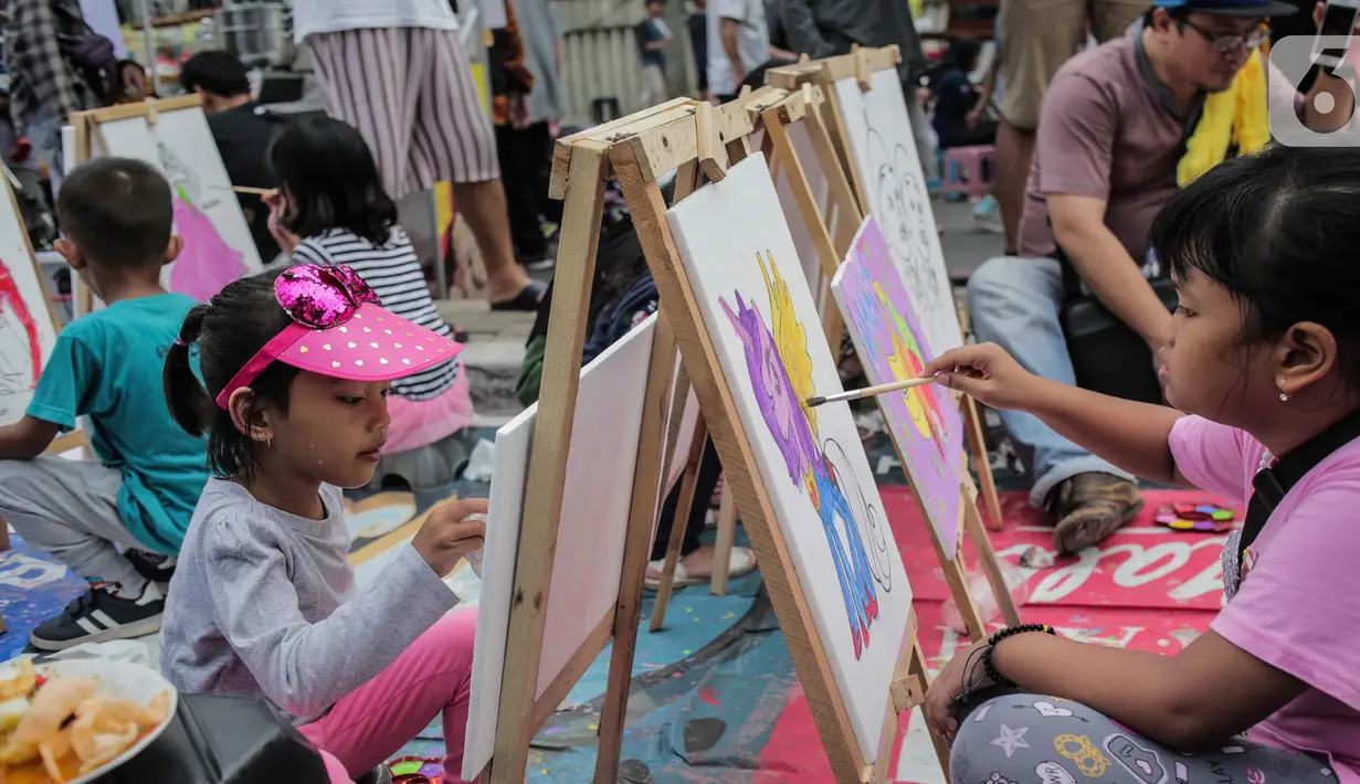 Anak-anak mewarnai gambar saat car free day (CFD) di kawasan Bundaran HI, Jakarta, Minggu (27/10/2019). Kegiatan tersebut digelar untuk melatih keterampilan motorik halus serta mengembangkan kreativitas dan imajinasi pada anak. (Liputan6.com/ Faizal Fanani)