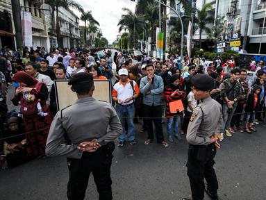 Petugas kepolisian menjaga ketat jalan yang dilalui Para kepala Negara dan delegasi dari Asia dan Afrika mengikuti 'Historical Walk' dalam rangkaian Peringatan KAA ke-60, di Jalan Asia Afrika, Bandung, Jumat (24/4/2015). (Liputan6.com/Faizal Fanani)