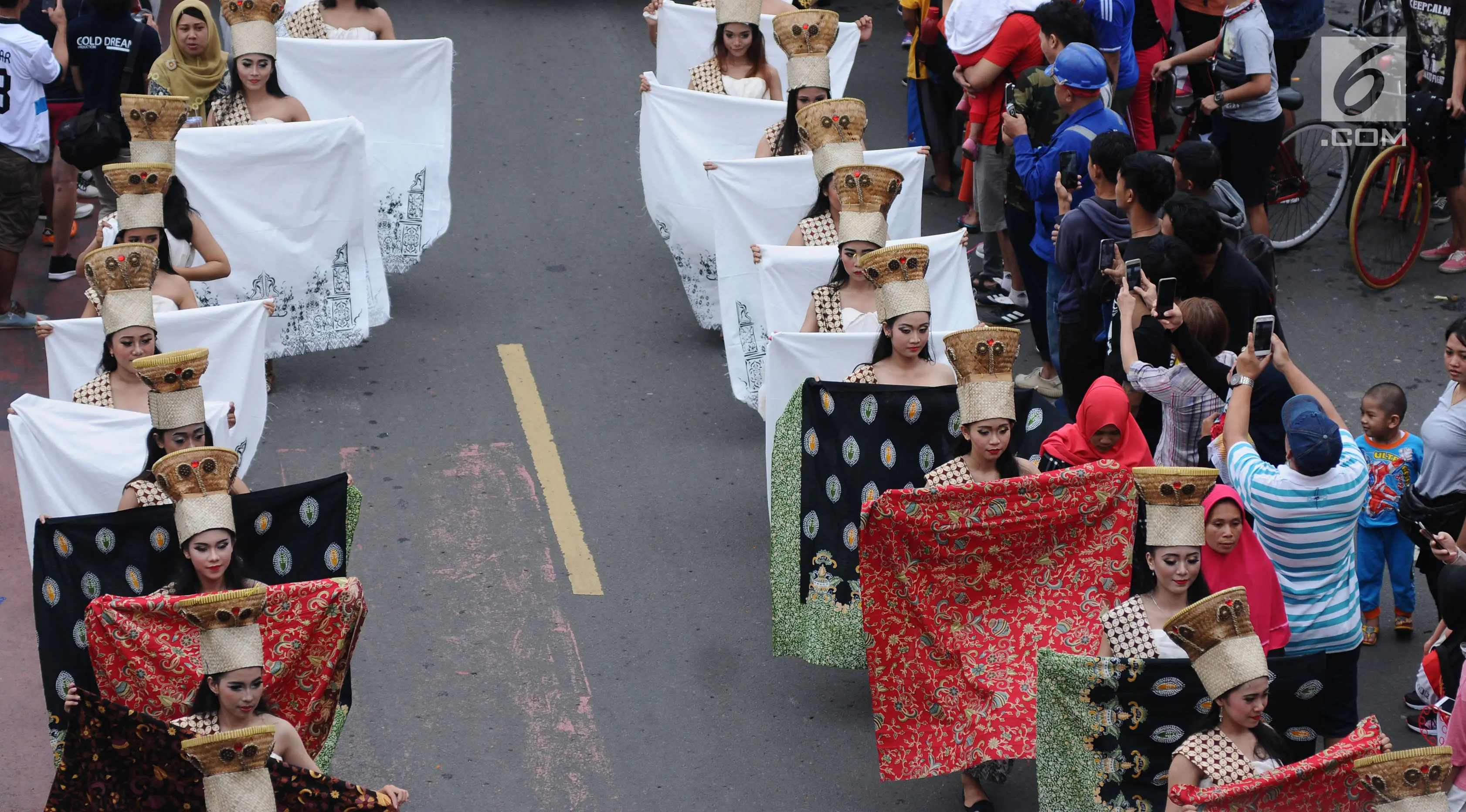 Model membawa beberapa batik saat berpawai pada perayaan Hari Batik Nasional di Hari Bebas Kendaraan di kawasan Bundaran HI, Jakarta, Minggu (1/10). Parade Batik Nusantara ini perayaan Hari Batik Nasional 2 Oktober. (Liputan6.com/Helmi Fithriansyah)