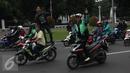 Pengemudi ojek online melintas di depan Istana Negara saat aksi ribuan supir menuntut pembekuan transportasi online, Jakarta, Selasa (22/3). Aksi tersebut berujung ricuh karena terjadi aksi saling lempar batu. (Liputan6.com/Gempur M Surya)