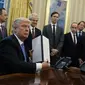Presiden Trump menandatangani perintah eksekutif anti-aborsi dengan didampingi sejumlah staf pria (Associated Press)