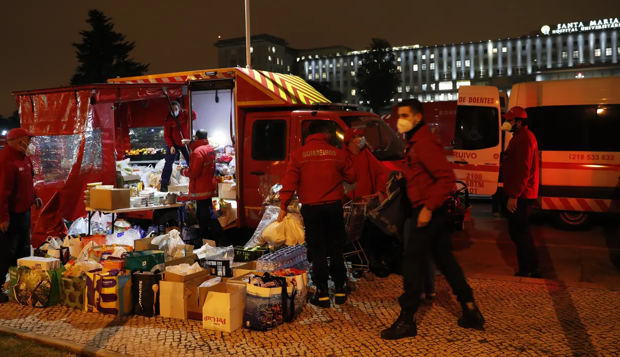 Petugas damkar menata makanan untuk kru ambulans pasien COVID-19 yang menunggu berjam-jam di rumah sakit Santa Maria di Lisbon, Kamis (28/1/2021). Di Portugal, fasilitas kesehatan berada di ambang kehancuran karena sudah kehabisan tempat tidur untuk merawat pasien corona. (AP/Armando Franca)