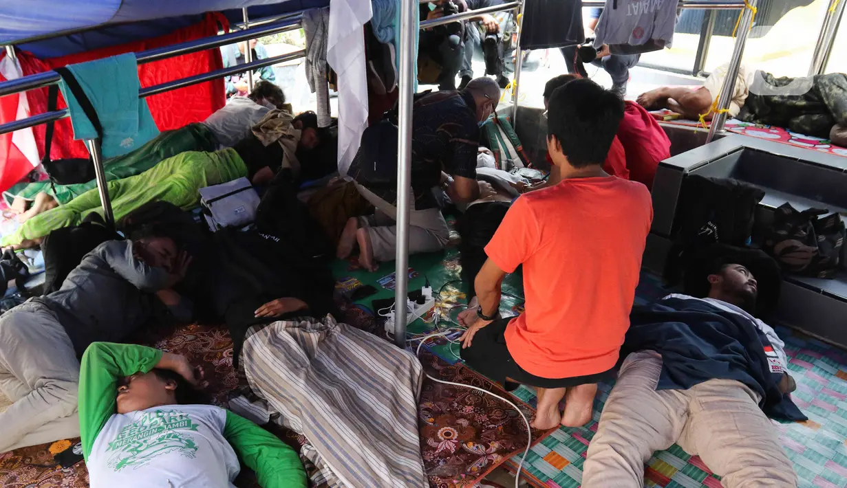 Sejumlah peserta aksi mogok makan beristirahat di dalam tenda di Komnas HAM, Jakarta, Minggu (18/12/2022). Sebanyak 5 peserta mogok makan yang melawan atas tindak kejahatan PT. Amman Mineral terhadap masyarakat Sumbawa Barat, tumbang akibat mengalami penurunan kesehatan dan dilarikan ke rumah sakit terdekat untuk mendapatkan perawatan medis. (Liputan6.com/Herman Zakharia)