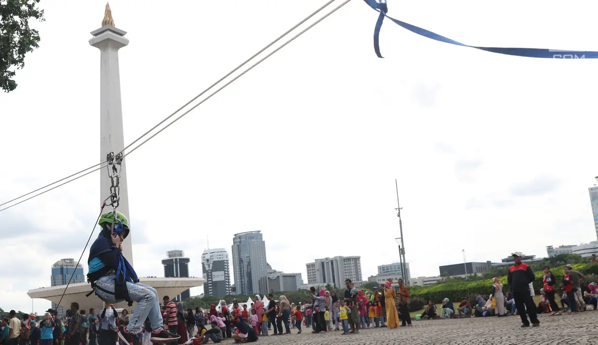 Seorang anak bermain flying fox atau meluncur melalui tali di kawasan Monumen Nasional, Jakarta, Selasa (1/1). Flying Fox gratis ini digelar untuk menambah pelayanan kepada warga yang berlibur di kawasan Monas. (Liputan6.com/Helmi Fithriansyah)
