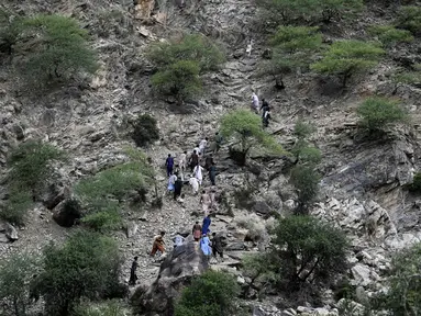 Warga dari kota dan desa sekitar terpaksa harus mendaki saat mencoba mencapai wilayah yang dilanda gempa untuk membantu para korban di distrik Nurgol, provinsi Kunar, Afghanistan timur, Selasa 2 September 2025. (AP Photo/Nava Jamshidi)