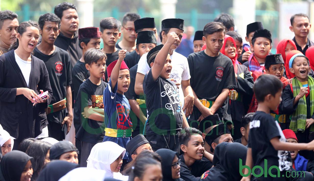 Para Pendekar Cilik Betawi saat menyaksikan gerakan Silat Betawi di Kawasan Senayan, Jakarta, Minggu (8/11/2015). Kegiatan ini merupakan  bagian dari Silahturahmi Main Pukul Betawi. (Bola.com/Nicklas Hanoatubun)