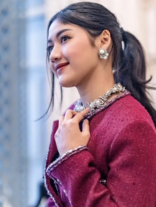 Ia semakin tampil menawan dengan kalung dan anting-anting mutiara dari artisan lokal Aidan dan Ice. Dengan gaya rambut ikat belakang. Credit: Instagram/(@erinagudono)
