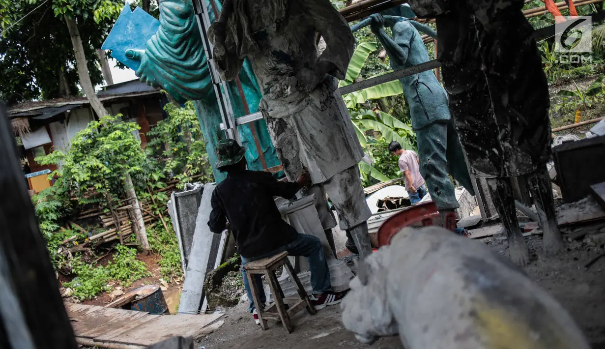 Perajin Sutopo membuat pesanan patung raksasa di kawasan Pondok Cabe, Tangerang Selatan, Jumat (14/12). Ukuran patung raksasa ini sampai 10 meter dan telah dijual hingga luar negeri. (Liputan6.com/Faizal Fanani)