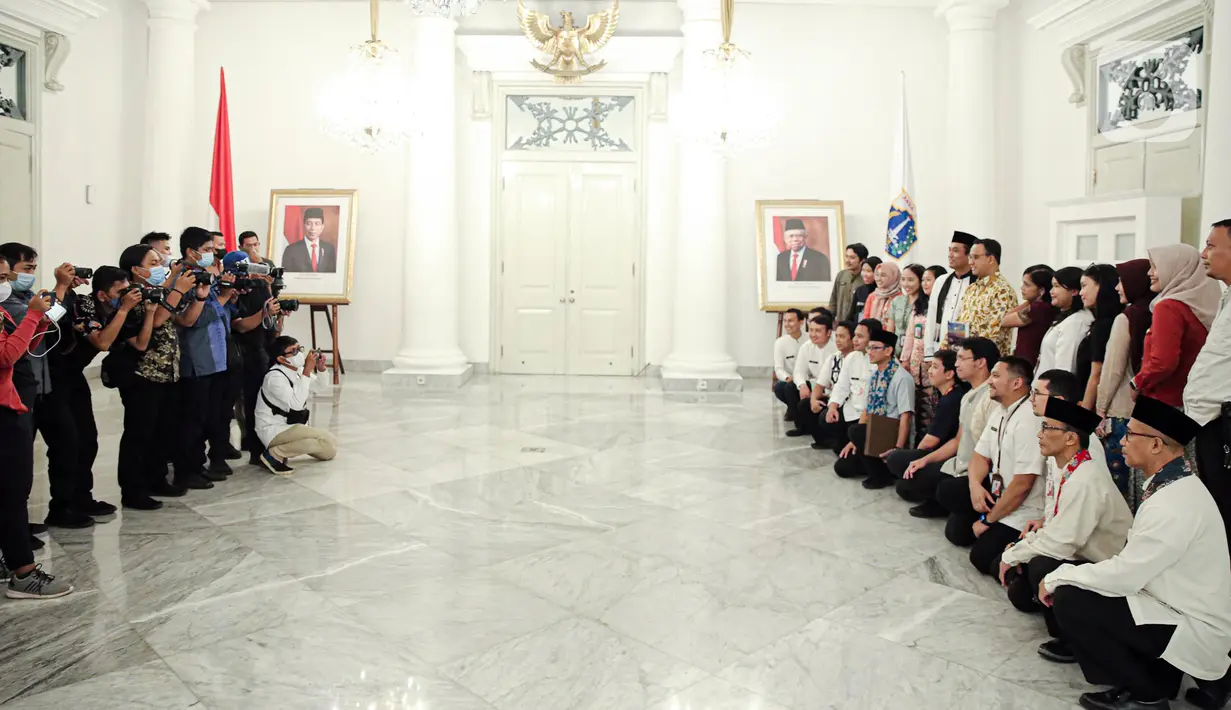 Gubernur DKI Jakarta Anies Baswedan (kanan tengah) berfoto bersama para Aparatur Sipil Negara (ASN) di Balai Kota DKI Jakarta, Jumat (14/10/2022). Di hari terakhir menjabat sebagai Gubernur DKI Jakarta, Anies Baswedan menyempatkan diri untuk menyapa ASN di Balai Kota. (Liputan6.com/Faizal Fanani)