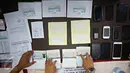 Petugas imigrasi menunjukan barang bukti dan tersangka saat rilis sindikat internasional pemalsuan dokumen keimigrasian di Kantor Imigrasi Jakarta Pusat, Rabu, (18/1). (Liputan6.com/Immanuel Antonius)
