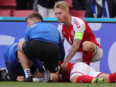 Simon Kjaer adalah orang paling berjasa pada momen ini. Kapten Denmark ini langsung memberikan pertolongan pertama dengan cara memastikan lidah Eriksen tidak menggangu pernafasannya. Selain itu ia juga menenangkan istri Eriksen yang sangat cemas di pinggir lapangan. (Foto: AFP/Pool/Friedemann Vogel)