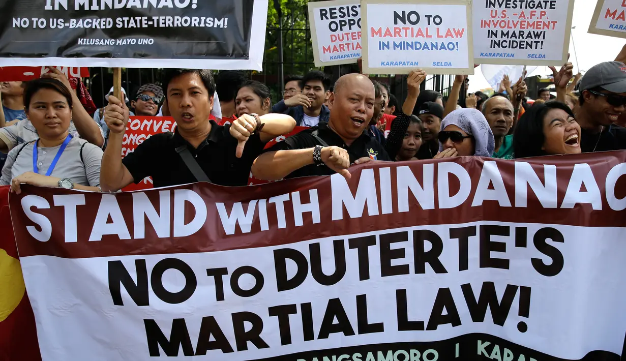 Sejumlah orang menggelar aksi menentang deklarasi darurat militer di depan Gedung DPR Filipina, Manila, Rabu (31/5). Mereka menolak deklarasi darurat militer di Mindanao yang diumumkan Duterte pada pertengahan Juli 2017. (AP Photo / Aaron Favila)