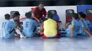Pelatih Spirit F4C memberikan arahan kepada anak asuhnya pada Super Soccer Futsal Battle di Lapangan Blok S, Jakarta, Sabtu (15/9/2018). Sebanyak 32 tim yang berlaga merupakan tim yang lolos dari babak eliminasi. (Bola.com/M Iqbal Ichsan)
