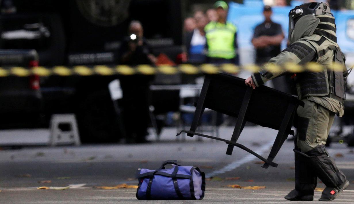 Petugas Penjinak Bahan Peledak dari Kepolisian Brasil mempersiapkan peralatan sebelum menghampiri tas mencurigakan di Rio de Janeiro, Senin (18/7). Pemerintah Brasil memperketat keamanan jelang Olimpiade Rio de Janiero 2016. (REUTERS/Ueslei Marcelino)