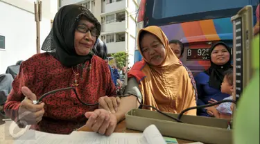 Petugas melakukan pemeriksaan kepada warga rusun Cibesel yang hendak mengikuti program KB di Rusun Cibesel, Jakarta, Selasa (23/8/2016). Mobil unit pelayanan KB DKI Jakarta sambangi warga rusun Cipinang Besar Selatan. (Liputan6.com/Yoppy Renato)