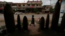 Seorang wanita berjalan melewati sebuah restoran dihiasi dengan bom dan belum meledak yang dijatuhkan oleh pesawat-pesawat Angkatan Udara AS selama Perang Vietnam, di Desa Ban Napia, Provinsi Xieng Khouang, Laos (03/9). (REUTERS/Jorge Silva)